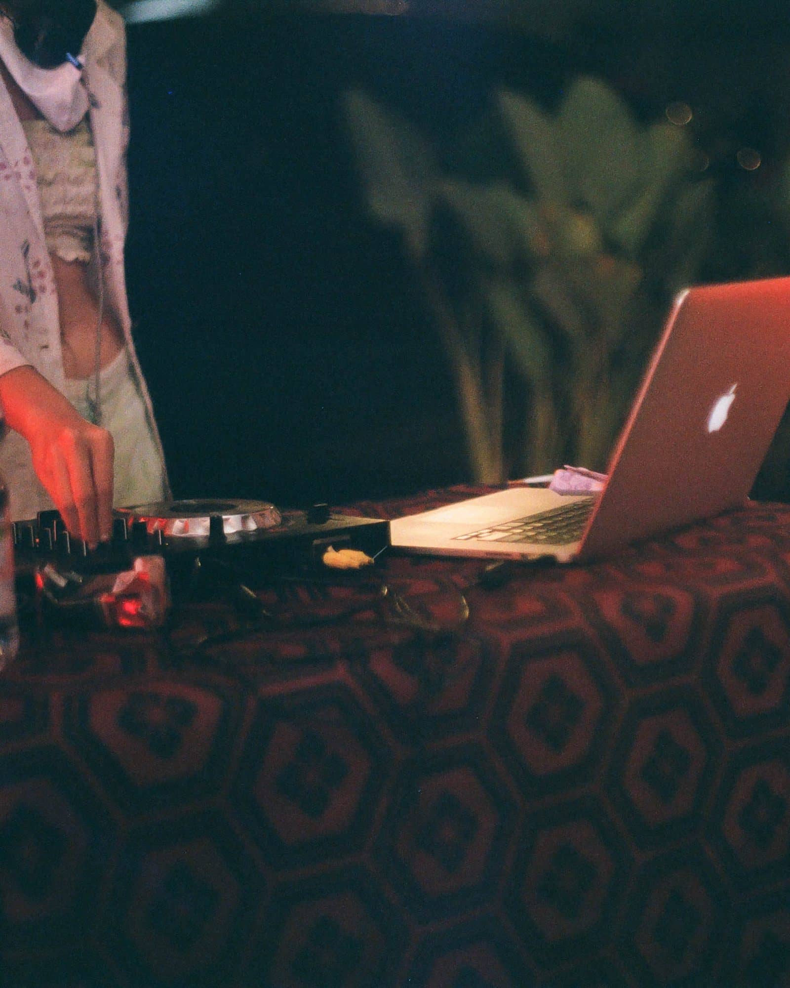 hands on the decks, a macbook, a batik tablecloth