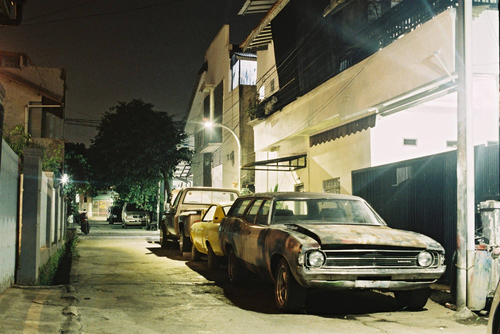 an old station wagon asleep under a streetlight