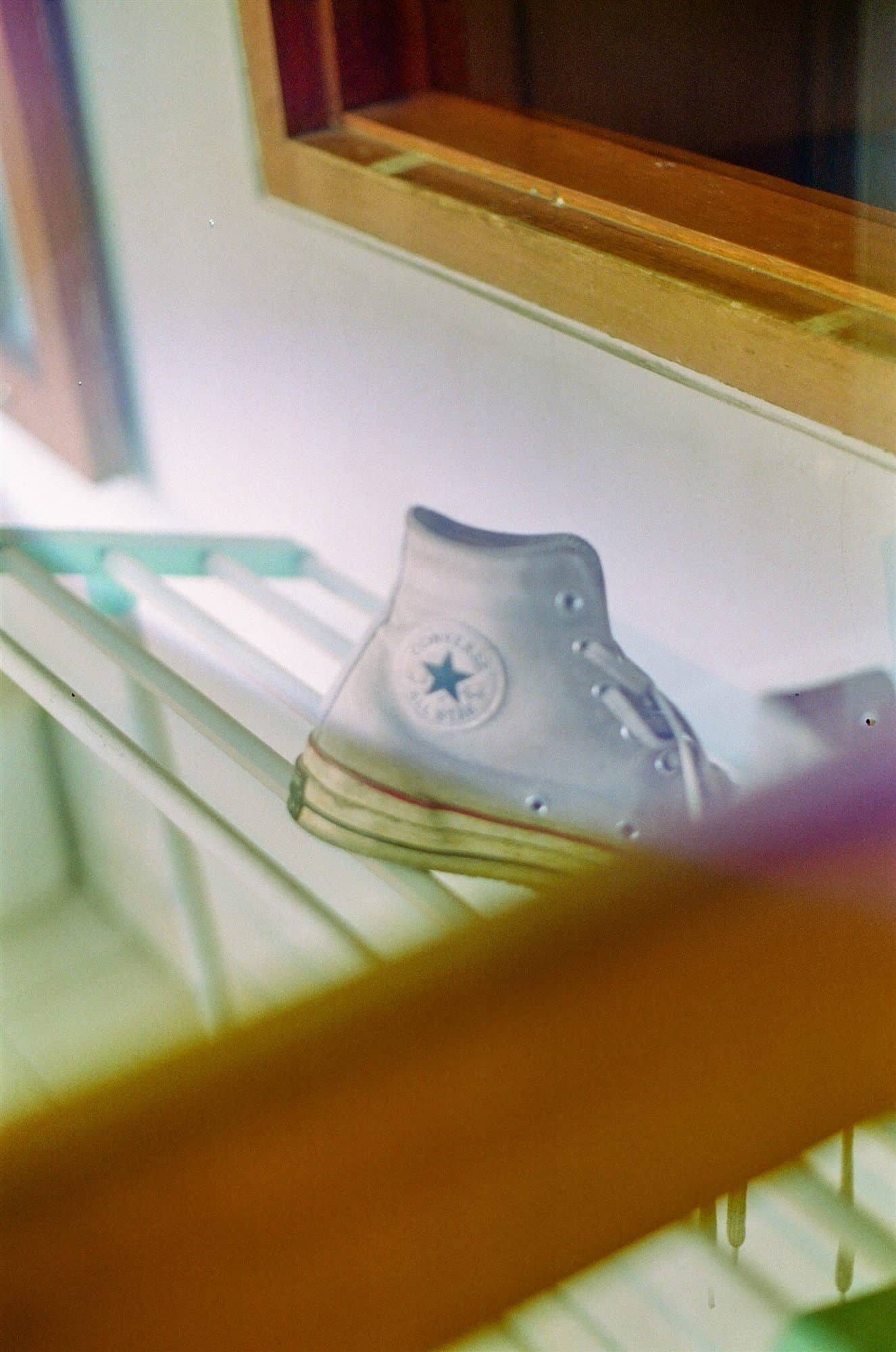 a converse drying on the rack, shot through glass